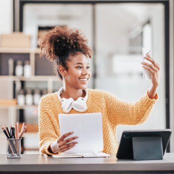 African american student woman in sweater video conference on smartphone to studying lesson online class and talking with classmates while sitting to learning knowledge and education in university.