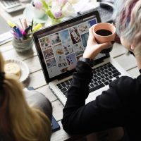 Woman Hands Holding Coffee Cup Working on Laptop